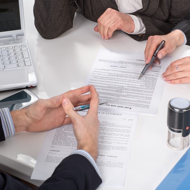 hands of three people, signing documents