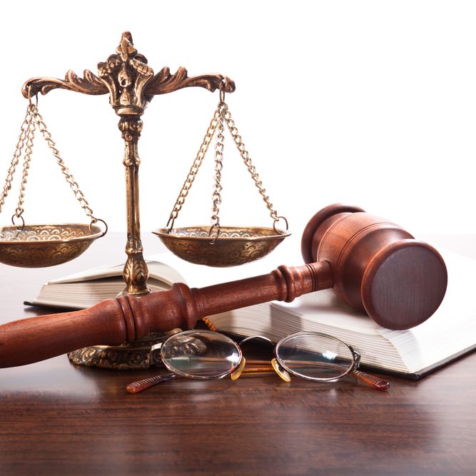 Bronze scales, gavel, glasses and a book on the table